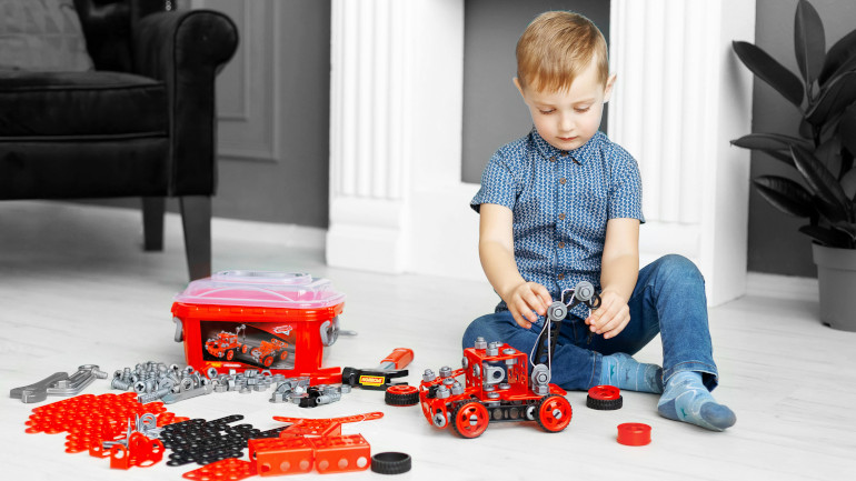 Enfant qui joue avec un jouet Meccano